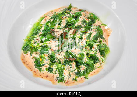 De délicieux fruits de mer marinés, salade verte fond isolé Banque D'Images