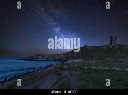 Superbe Voie Lactée dynamique composite image sur paysage de Château de Dunstanburgh sur la côte de Northumberland en Angleterre Banque D'Images