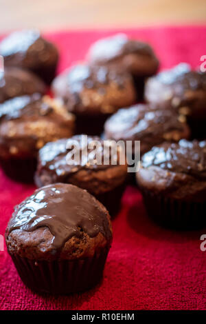 Muffins au chocolat close up sur tissu rouge. Tir vertical. Banque D'Images