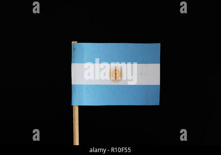 Un drapeau bleu et blanc de l'Argentine au cure-dent sur fond noir. Une lumière horizontale de triband bleu et blanc avec le soleil de mai centere Banque D'Images