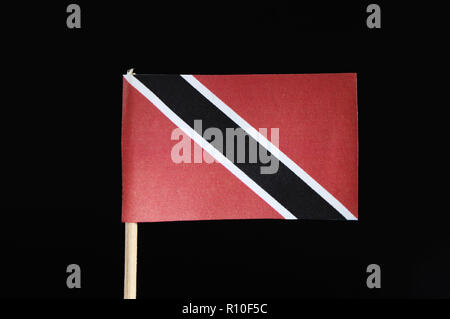 Un drapeau original et officiel de la Trinité-et-Tobago sur le cure-dents sur fond noir. Un champ rouge avec une arme blanche de la bande diagonale noire Banque D'Images