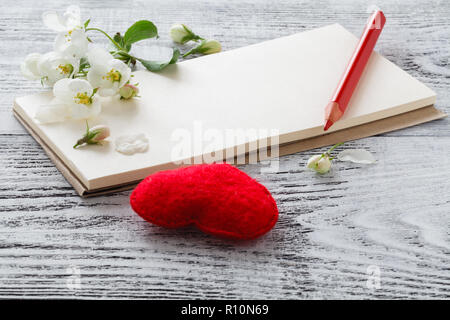 Coeur rouge, la floraison sprig, sur carte-cadeau, autour de brins d'amandes à fleurs sur fond de bois Banque D'Images