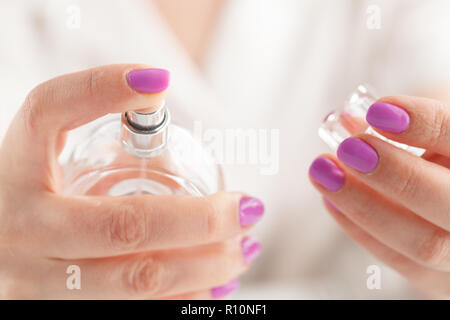 Doigt qui appuie sur le pulvérisateur sur flacon de parfum Banque D'Images