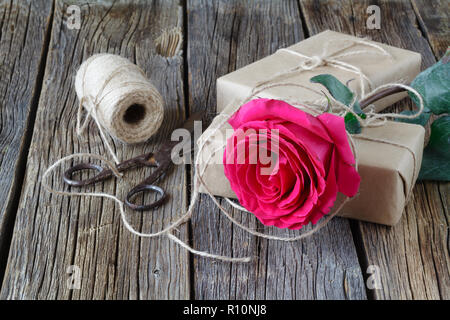 Roses rouges et boîte-cadeau sur un fond de bois Banque D'Images