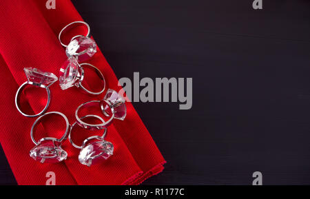 Big diamond rings sur la serviette de table rouge sur la table en bois Banque D'Images