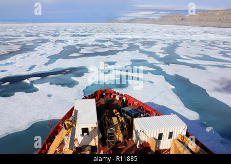 Chercheur scientifique à la proue de l'Amundsen comme elle brise la glace dans le détroit de Lancaster, l'Arctique canadien Banque D'Images