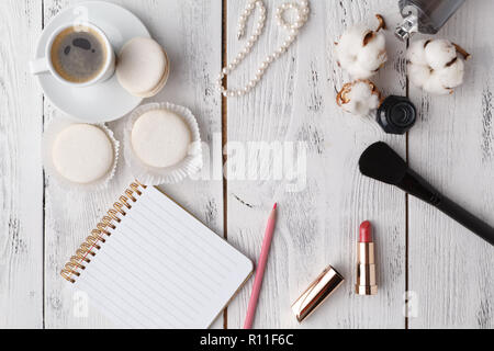 Café, gâteau macaron, propre ordinateur portable, lunettes et rose fleur sur table à partir de ci-dessus. Travail des femmes 24. Petit déjeuner agréable. Mise à plat de style. Banque D'Images