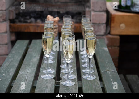 Trois lignes de champagne dans les verres sur une table de pique-nique Banque D'Images