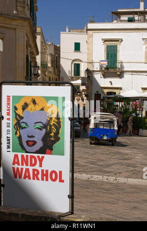 Via Alfonso d'Aragona, Otranto, Pouilles, Italie : une affiche publicitaire de l'Andy Warhol exposition 'Je veux être une machine" Banque D'Images