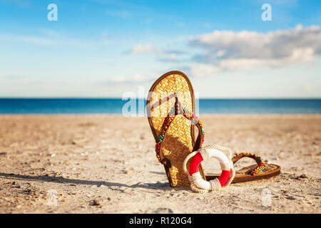 Tongs et bouée sur plage de sable fin. Vacances d'été sur la mer Baltique, l'Allemagne. Concept de sécurité Banque D'Images