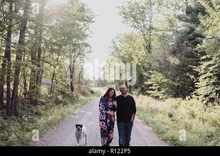 Couple walking with dog sur route de campagne Banque D'Images