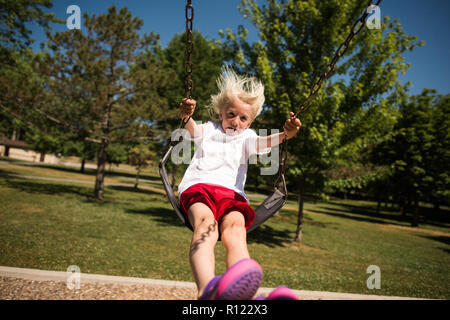 Boy on swing in park Banque D'Images