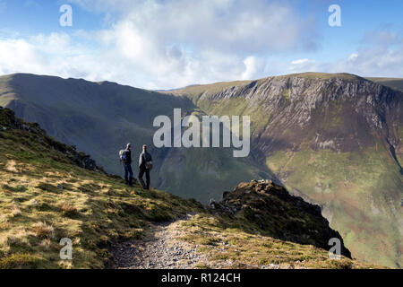 Deux promeneurs appréciant la vue du rocher d'Anguille Spy Haut vers Dale Head (à gauche) et Hindscarth (droite), Lake District, Cumbria, Royaume-Uni. Banque D'Images