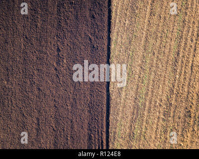 Photo aérienne d'un champ labouré dans une campagne. Le labour à l'automne, saison de tir de drone ci-dessus. Banque D'Images