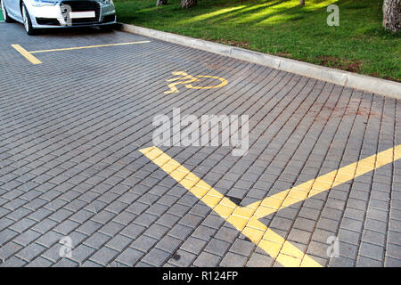 Poster avec stationnement pour handicapés et connectez-vous à l'avant de la baie de stationnement en stationnement / parking marqué pour les personnes ayant des besoins spéciaux / symbole handicapés. Banque D'Images