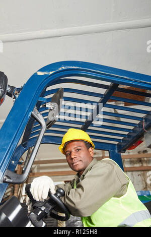Travailleur de l'Afrique sur un chariot élévateur à l'entrepôt ou dépôt Banque D'Images
