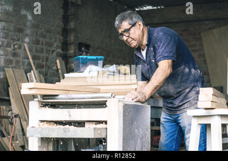 Carpenter en utilisant à bande. Le sablage d'un charpentier bois avec à bande Banque D'Images