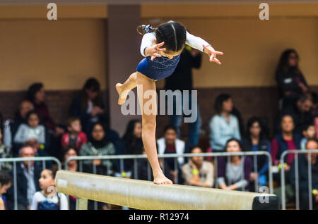 Jeune femme gymnast performing handstand sur poutre, side view Banque D'Images