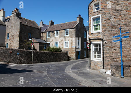 Maisons anciennes en grès Stromness, Orkney avec pierres de pavage d'une carrière locale et de galets pierres dans le centre de la rue. Banque D'Images