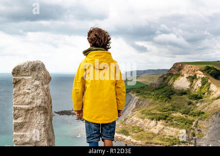 Garçon sur la falaise surplombant la mer, Bournemouth, Royaume-Uni Banque D'Images