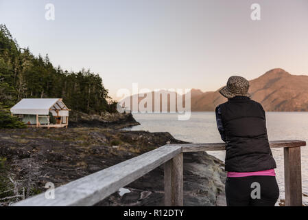 Woman relaxing by Lakeside, le détroit de Johnstone, Telegraph Cove, Canada Banque D'Images