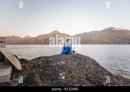 Woman relaxing by Lakeside, le détroit de Johnstone, Telegraph Cove, Canada Banque D'Images