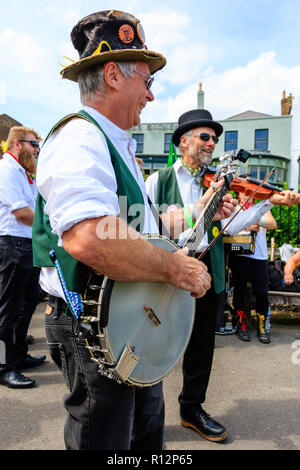 Festival de la semaine folklorique de Broadstairs. Le joueur de banjo man du Maldon Greenjackets Morris, jouer dehors sur la promenade avec les autres. Banque D'Images