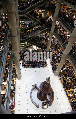 Londres, Royaume-Uni. 9 Nov 2018. Des milliers de l'atrium et les escaliers mécaniques de la Lloyd's, service de commémoration. Pétales de pavot tombent d'en haut dans l'atriium comme le clairon joue 'le Dernier Post' . La Lutine Bell sons pendant la cérémonie de dépôt des dignitaires, dont le maire de Londres et Chelsea retraités avec les fusils 7 composant la garde d'honneur Crédit : Tommy Londres/Alamy Live News Banque D'Images