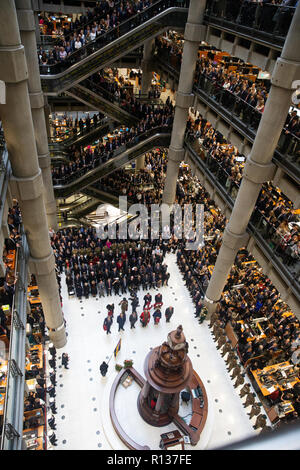 Londres, Royaume-Uni. 9 Nov 2018. Des milliers de l'atrium et les escaliers mécaniques de la Lloyd's, service de commémoration. Pétales de pavot tombent d'en haut dans l'atriium comme le clairon joue 'le Dernier Post' . La Lutine Bell sons pendant la cérémonie de dépôt des dignitaires, dont le maire de Londres et Chelsea retraités avec les fusils 7 composant la garde d'honneur Crédit : Tommy Londres/Alamy Live News Banque D'Images