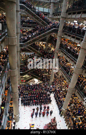 Londres, Royaume-Uni. 9 Nov 2018. Des milliers de l'atrium et les escaliers mécaniques de la Lloyd's, service de commémoration. Pétales de pavot tombent d'en haut dans l'atriium comme le clairon joue 'le Dernier Post' . La Lutine Bell sons pendant la cérémonie de dépôt des dignitaires, dont le maire de Londres et Chelsea retraités avec les fusils 7 composant la garde d'honneur Crédit : Tommy Londres/Alamy Live News Banque D'Images