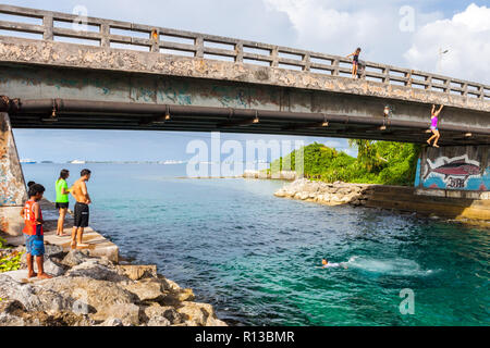 L'atoll de Majuro, Îles Marshall, Micronésie, Océanie - 4 jan 2012 : Enfants et adolescents de sauter un pont à Majuro lagon turquoise bleu azur. Banque D'Images