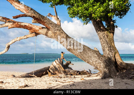 Laura beach. Lagon turquoise bleu azur. L'atoll de Majuro, Îles Marshall, Micronésie, l'Océanie. Touriste fait une photo debout sur une souche. Banque D'Images