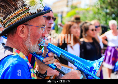 Festival de la semaine folklorique de Broadstairs. Senior male, musicien folk, debout à l'extérieur avec d'autres, tout en jouant un trombone bleu . Banque D'Images