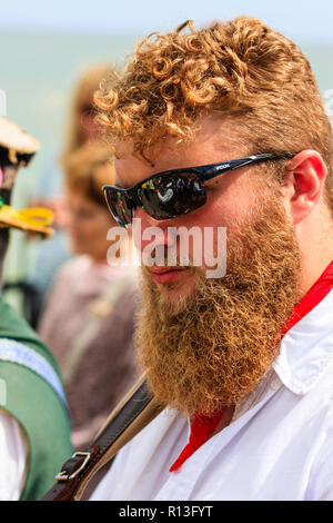 Broadstairs Folk semaine. Jeune homme, 20 ans, debout à l'extérieur avec des lunettes sur et très buissonnante couleur gingembre barbe. Expression très grave. Banque D'Images