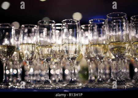 Détails flous avec des verres de champagne en attente d'être servi à des gens qui arrivent à un point de vue parti (ivre) Banque D'Images