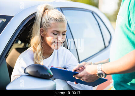 Auto-école. Jeune femme ou étudiante de conduite sur un examen de conduite avec son instructeur. Apprendre à conduire une voiture. Auto-école de l'instructeur en donnant l'exa Banque D'Images