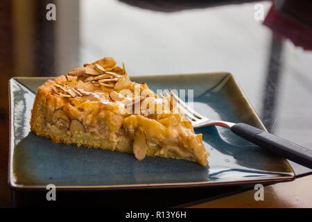 Délicieux gâteau aux amandes apple kuchen et la fourche sur plaque carrée bleue. Dessert, concepts d'épicerie fine Banque D'Images