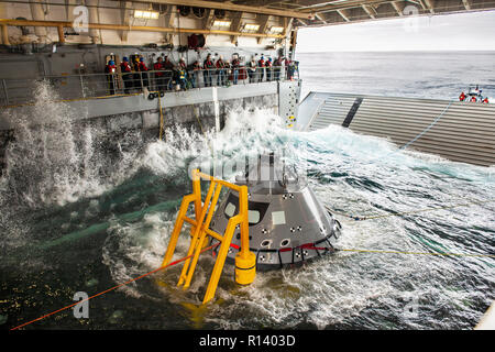 Les membres de l'équipe de rétablissement de la NASA watch comme une version d'essai de la capsule Orion est attiré dans le même pont de l'USS John P. Murtha lors d'un test de récupération, 30 octobre 2018 dans l'océan Pacifique. La NASA et la marine américaine n'a pas effectué l'océan ouvert récupération d'un vaisseau spatial habité depuis le projet Apollo dans les années 60 et sont des procédures d'essai et le matériel qui sera utilisé pour récupérer le vaisseau Orion après il éclaboussures vers le bas dans l'océan Pacifique à la suite des futures missions d'exploration spatiale. Banque D'Images