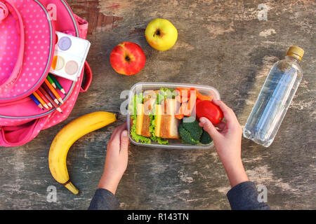 Sandwiches, fruits et légumes en boîte alimentaire, sac à dos sur le vieux fond de bois. Concept de l'alimentation à l'école de l'enfant. Vue d'en haut. Mise à plat. Banque D'Images