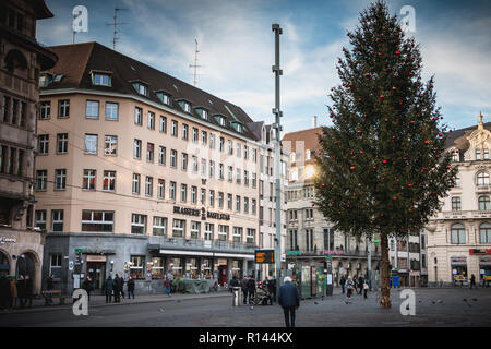 Bâle, Suisse - 25 décembre 2017 - les gens marchent tranquillement sur la place du marché ornée de son arbre de Noël pour la fin de l'année. Banque D'Images