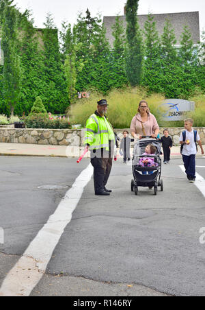 Cross de l'école à pied aidant garde la mère et les enfants de l'autre côté de la rue, banlieue de Boston, Massachusetts, USA Banque D'Images