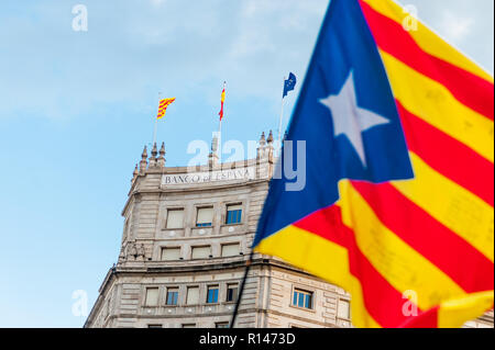 Brandir le drapeau catalan en face de la banque d'espagne bâtiment dans le centre-ville de Barcelone au cours d'indepence symbole de mars question économique Banque D'Images