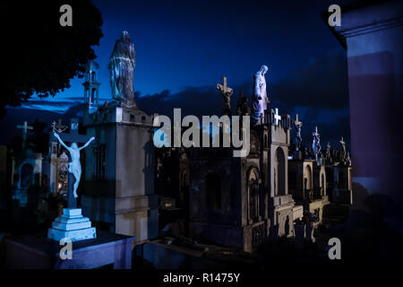 Jejus statues at bleu foncé pierres tombales allégé au cours de l'aube dans Cementerio général à Mérida, Mexique Banque D'Images