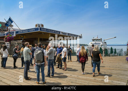 SEATTLE, Washington State, USA - Juin 2018 : Visiteurs wiating sur le front de mer de Seattle pour une croisière dans le port de départ. Banque D'Images