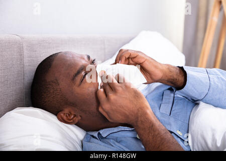 Close-up d'un jeune homme africain soufflant son nez Banque D'Images