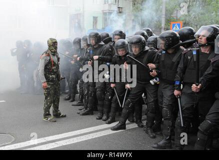 28 avril 2014 - Donetsk, Ukraine : un pro-Russie leader séparatiste affronte d'un escadron de la police antiémeute ukrainienne en essayant de protéger une manifestation pacifique des Ukrainiens en faveur de l'unité de leur pays. La peur est visible sur le visage des policiers parce qu'ils savent qu'il y a des centaines d'autres séparatistes violents dans les rues à proximité. En dépit de la protection de la police, le groupe pro-Russie a violemment attaqué et dispersé les manifestants pacifiques.Le groupe séparatiste pro-russe, en majorité des jeunes à Balaclava, ensuite célébré leurs actions en criant qu'ils avaient brisé le 'fascistes'. Une manif Banque D'Images