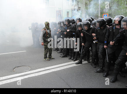 28 avril 2014 - Donetsk, Ukraine : un pro-Russie leader séparatiste affronte d'un escadron de la police antiémeute ukrainienne en essayant de protéger une manifestation pacifique des Ukrainiens en faveur de l'unité de leur pays. La peur est visible sur le visage des policiers parce qu'ils savent qu'il y a des centaines d'autres séparatistes violents dans les rues à proximité. En dépit de la protection de la police, le groupe pro-Russie a violemment attaqué et dispersé les manifestants pacifiques.Le groupe séparatiste pro-russe, en majorité des jeunes à Balaclava, ensuite célébré leurs actions en criant qu'ils avaient brisé le 'fascistes'. Une manif Banque D'Images