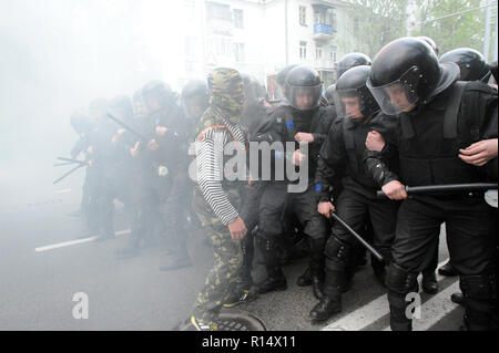 28 avril 2014 - Donetsk, Ukraine : un pro-Russie leader séparatiste affronte d'un escadron de la police antiémeute ukrainienne en essayant de protéger une manifestation pacifique des Ukrainiens en faveur de l'unité de leur pays. La peur est visible sur le visage des policiers parce qu'ils savent qu'il y a des centaines d'autres séparatistes violents dans les rues à proximité. En dépit de la protection de la police, le groupe pro-Russie a violemment attaqué et dispersé les manifestants pacifiques.Le groupe séparatiste pro-russe, en majorité des jeunes à Balaclava, ensuite célébré leurs actions en criant qu'ils avaient brisé le 'fascistes'. Une manif Banque D'Images