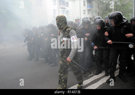 28 avril 2014 - Donetsk, Ukraine : un pro-Russie leader séparatiste affronte d'un escadron de la police antiémeute ukrainienne en essayant de protéger une manifestation pacifique des Ukrainiens en faveur de l'unité de leur pays. La peur est visible sur le visage des policiers parce qu'ils savent qu'il y a des centaines d'autres séparatistes violents dans les rues à proximité. En dépit de la protection de la police, le groupe pro-Russie a violemment attaqué et dispersé les manifestants pacifiques.Le groupe séparatiste pro-russe, en majorité des jeunes à Balaclava, ensuite célébré leurs actions en criant qu'ils avaient brisé le 'fascistes'. Une manif Banque D'Images