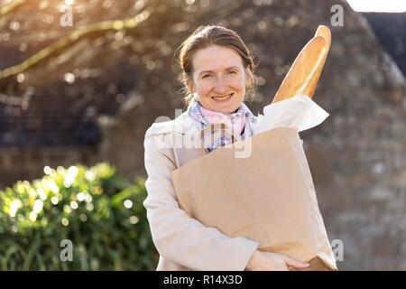 Jeune fille française avec la baguette sur le côté de la rue de la ville Banque D'Images